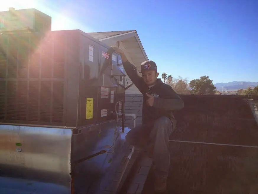 HVAC technician performing AC Tune-Up on a rooftop unit in Tinton Falls